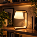Kiro Aven minimalist table lamp with a white shade, smooth curved frame and brown base, featuring integrated cool-white LED lighting.
