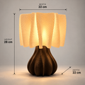 A table lamp with a glowing cream-colored textured shade and a dark brown ribbed bulb-shaped base, shown with dimension lines and labels indicating a height of 28 cm, width of 22 cm, and depth of 22 cm against a neutral gray background.