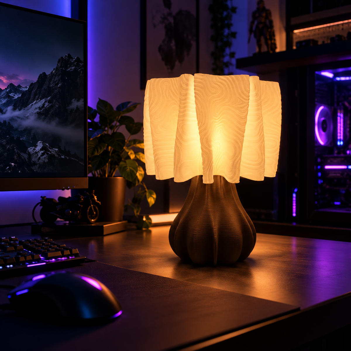 A modern table lamp with a textured, pleated white shade and a dark brown sculptural base, glowing warmly on a desk in a gaming setup.